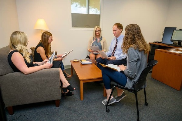 Professor E. Mark Cummings meeting with a group of students in an office
